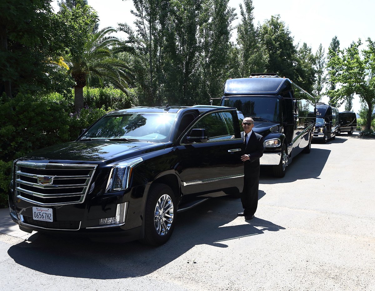 Chauffeur beside an Escalade with the fleet